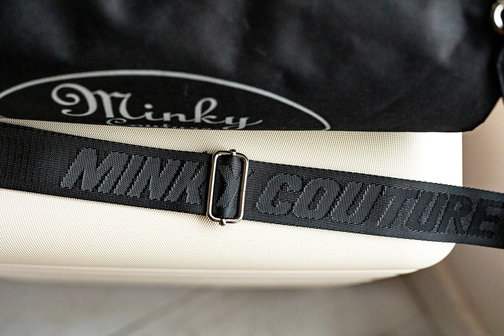 Carrying strap of a Minky Couture blanket travel bag, embossed with the words "Minky Couture"