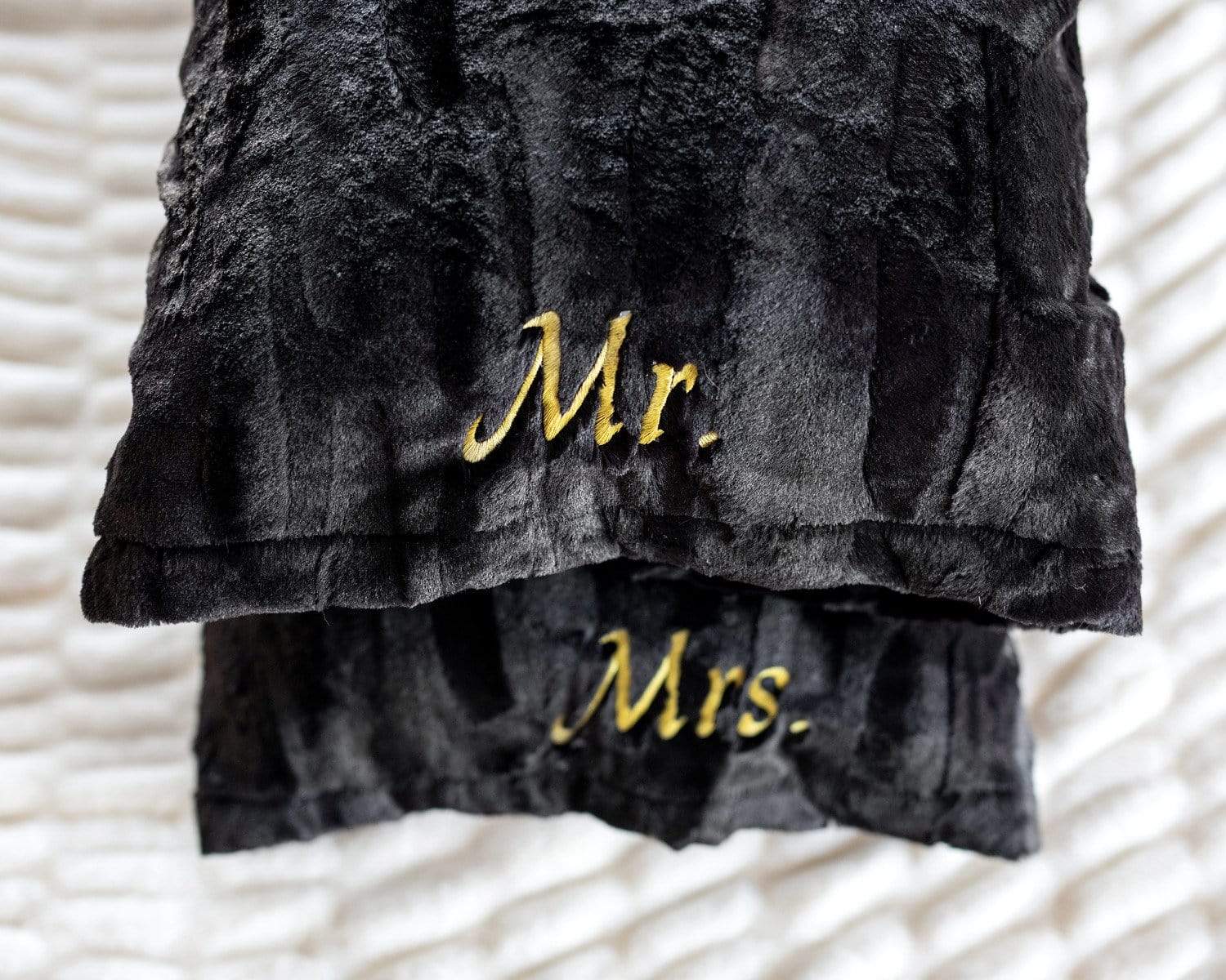 Black plush pillowcases by Minky Couture embroidered with Mr. and Mrs. in gold font. .