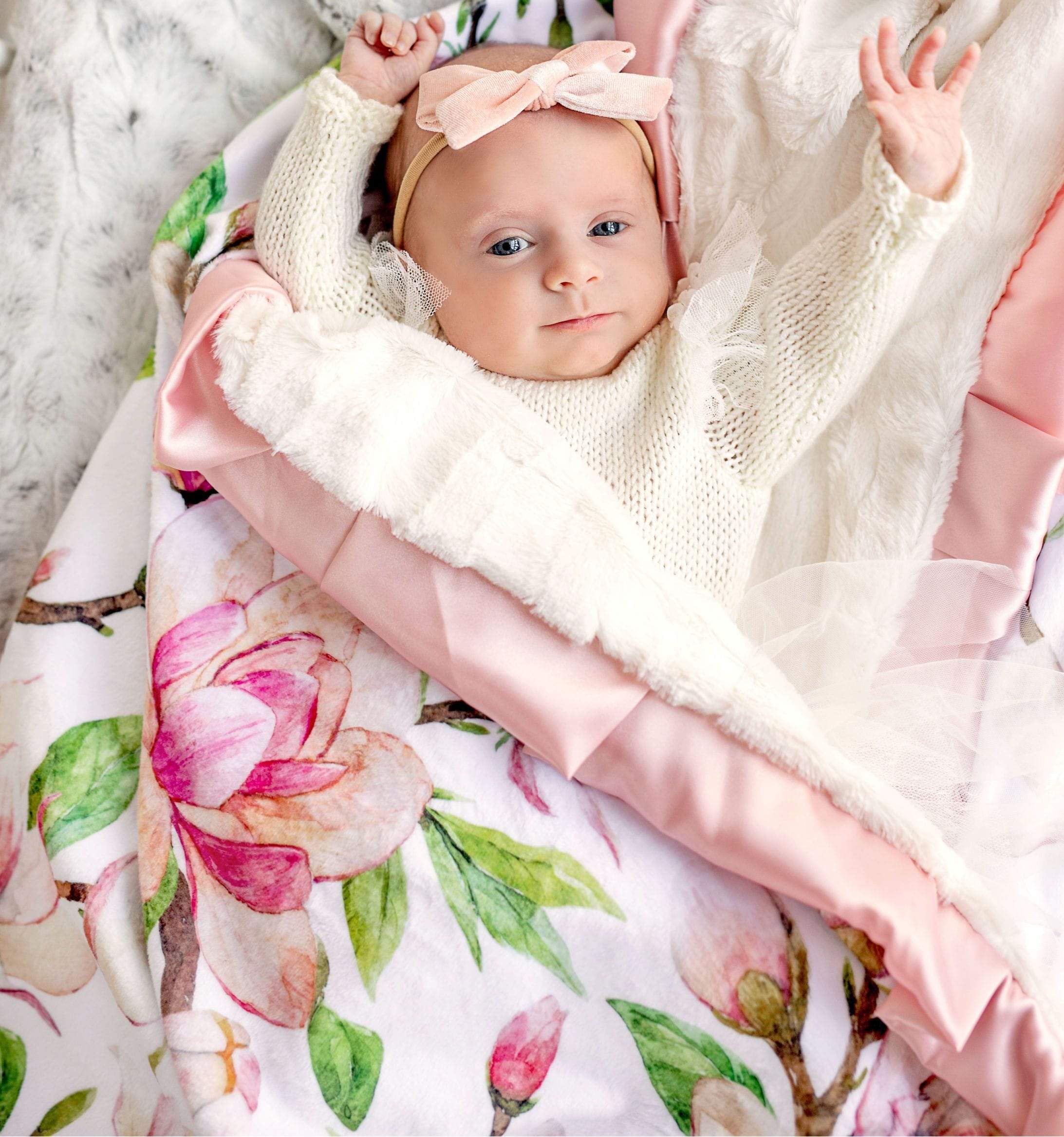 Baby girl wrapped up in the Pink Aspirations blanket by Minky Couture.
