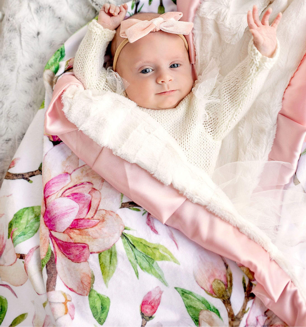 Baby girl wrapped up in the Pink Aspirations blanket by Minky Couture.
