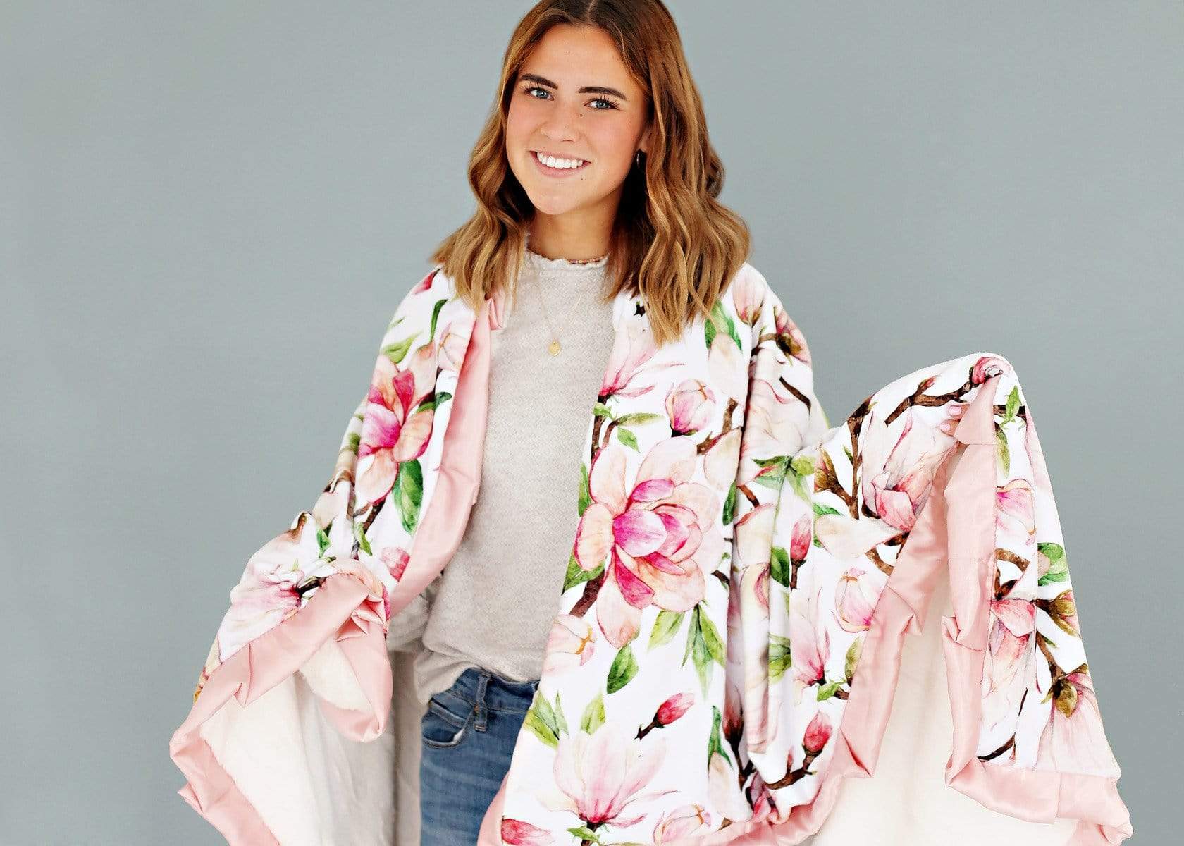 Young lady with the Pink Aspirations blanket by Minky Couture wrapped around her shoulders.