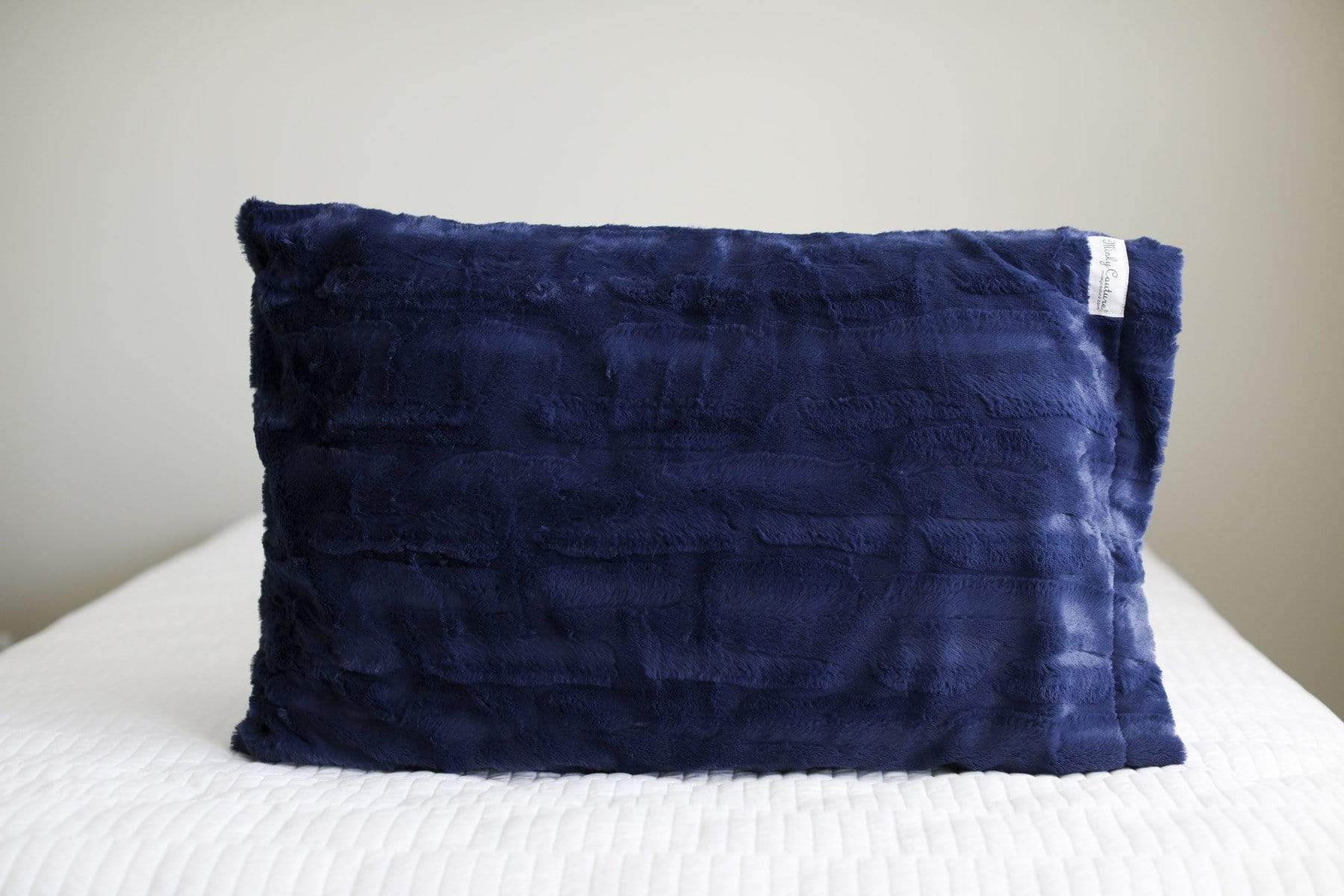 Navy blue Minky Couture pillowcase sitting on a bed. 