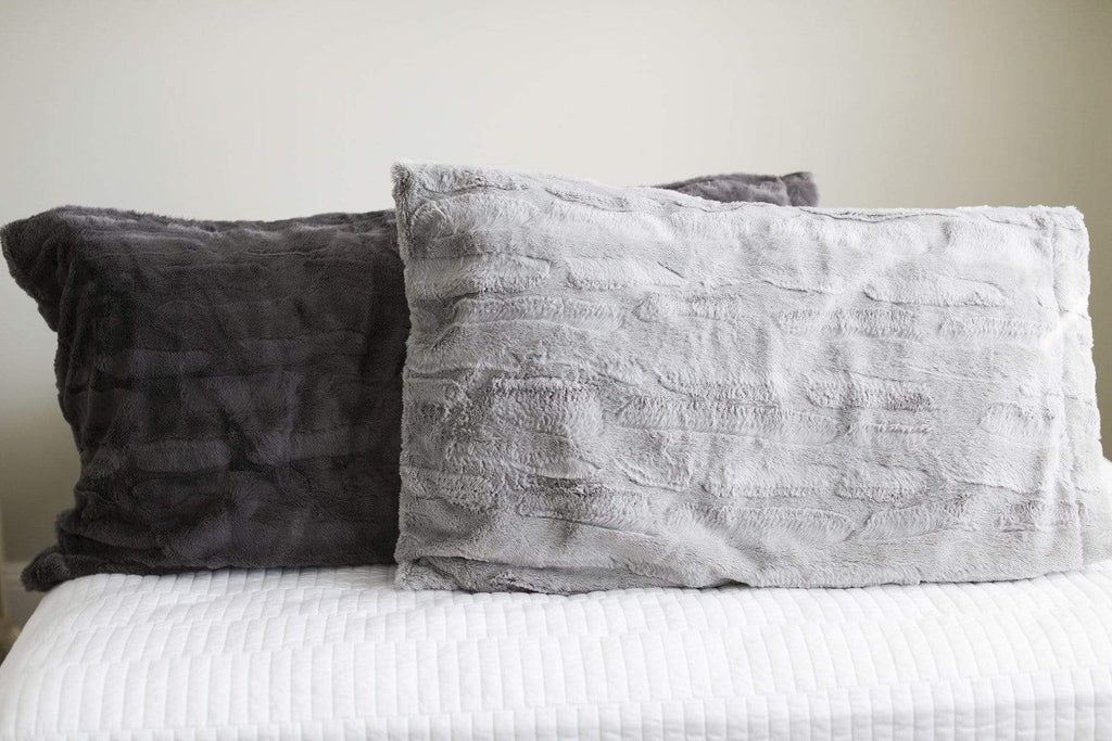 Charcoal and silver plush pillowcases by Minky Couture on a bed. 