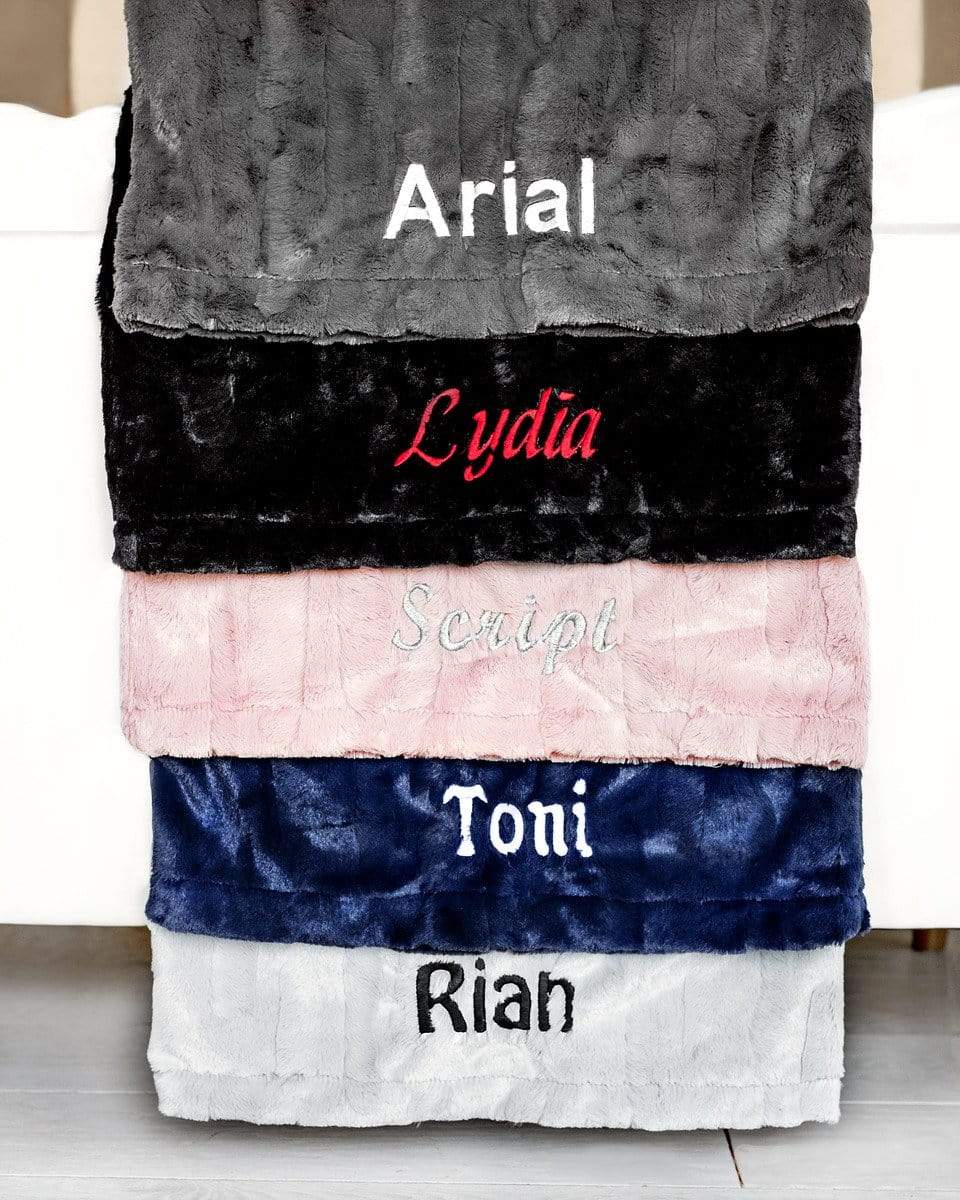 Five pillows of various colors embroidered with five different fonts to show options available to personalize a pillow. 